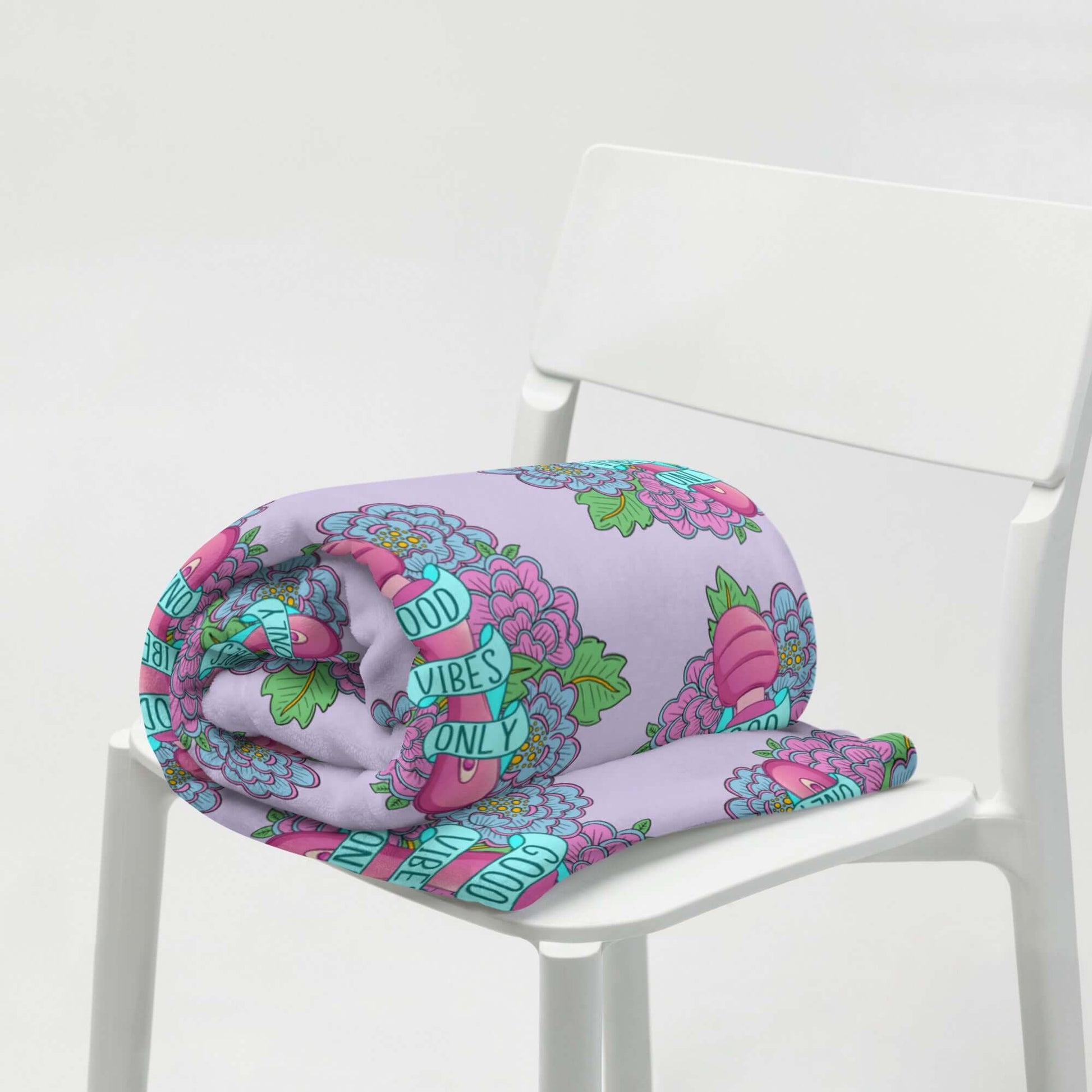 Lavender fleece throw blanket with graphic that has the words Good vibes only layered over a pink wand vibrator with flowers all around. The graphic is repeating all over the blanket.