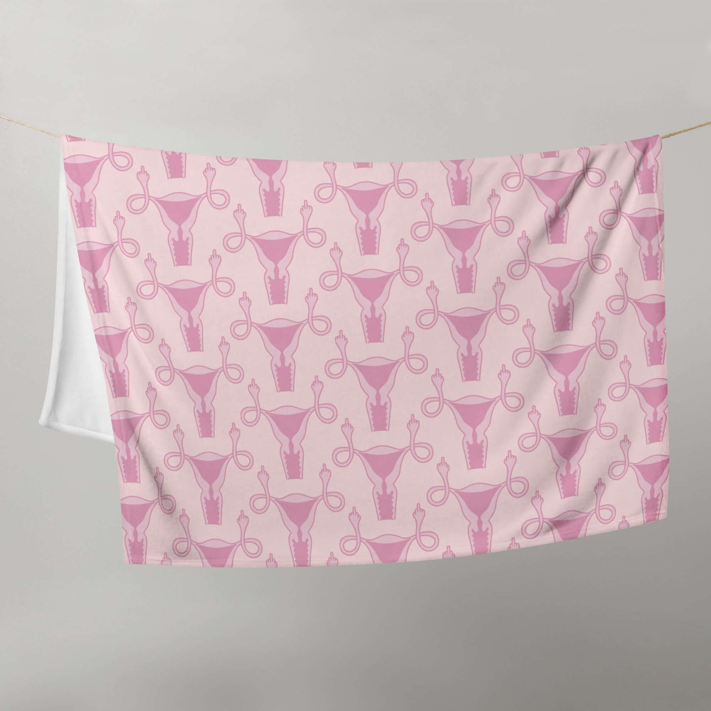 Pink fleece throw blanket with pink uterus flipping middle finger graphic printed all over.