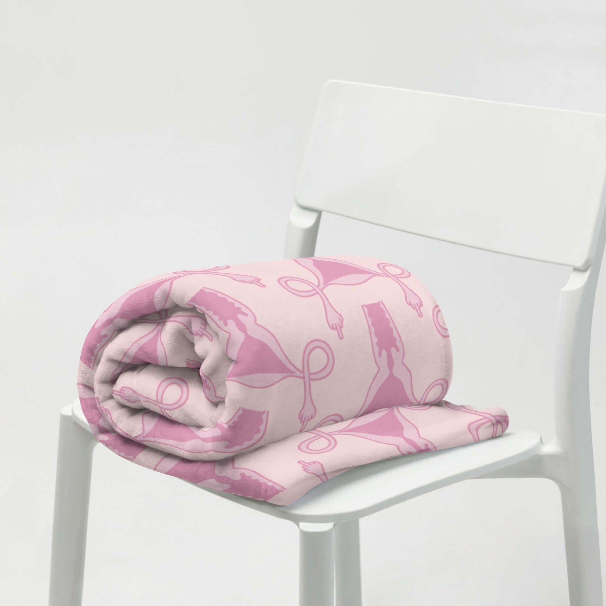 Rolled Pink fleece throw blanket with pink uterus flipping middle finger graphic printed all over.