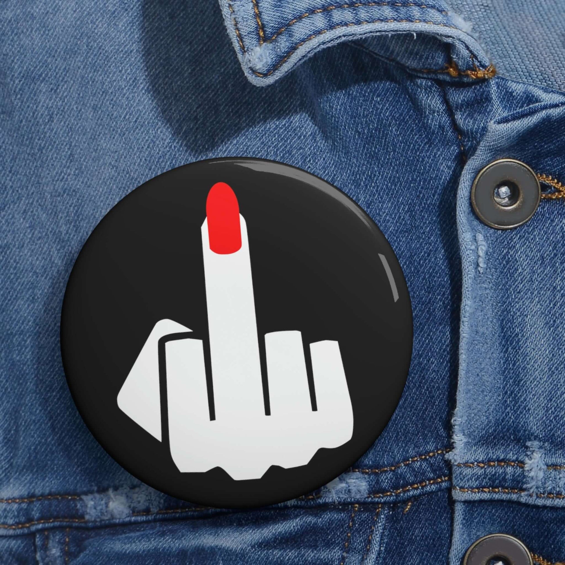 Pin-back button with silhouette of a ladies hand flipping the middle finger with a long red fingernail.