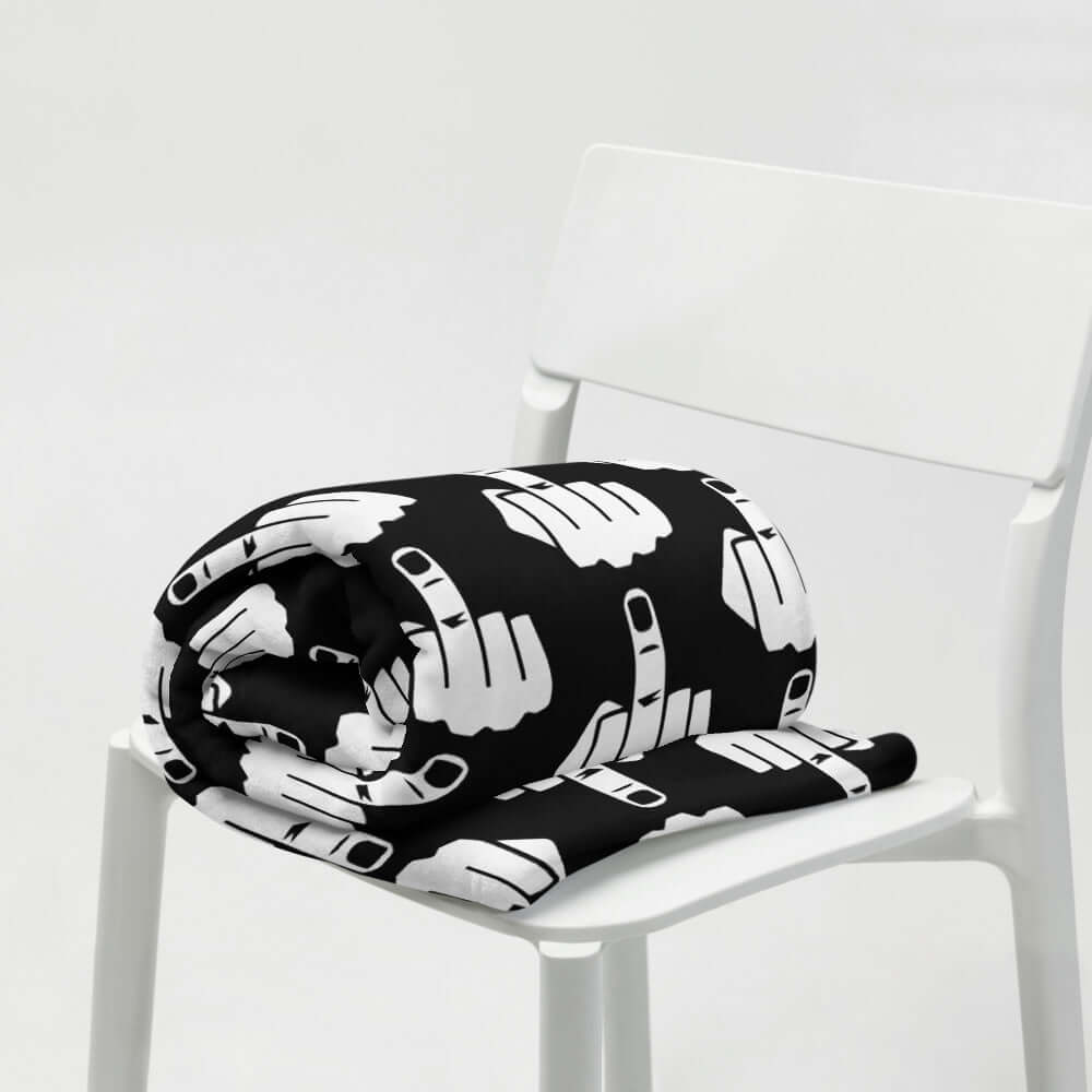 Throw blanket with image of middle finger silhouette printed all over. The blanket is black and the graphic is white.