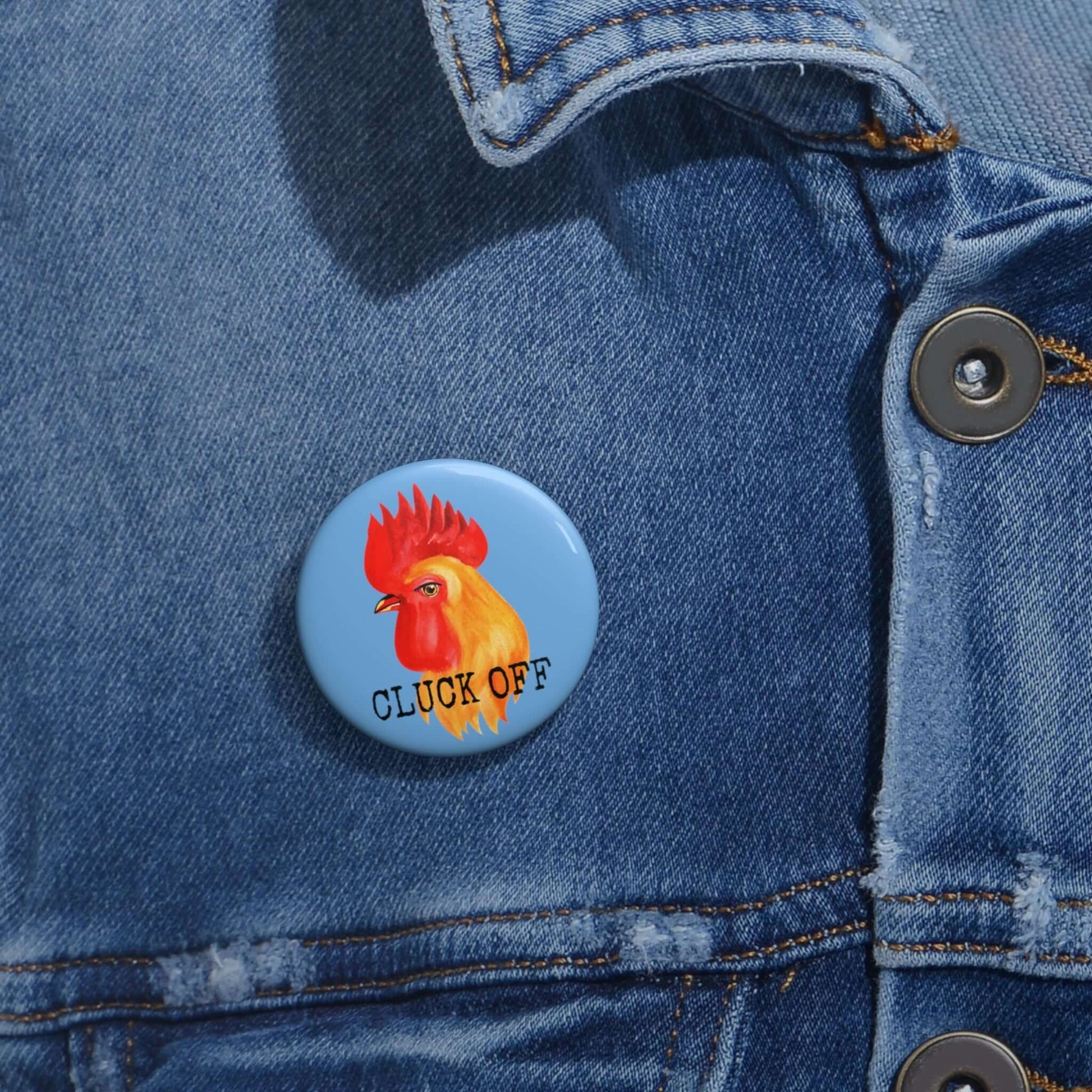 Light blue pun pinback button with image of a chicken and the words Cluck off beneath.