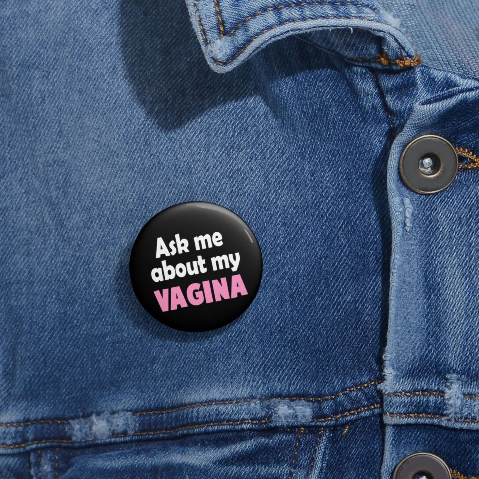 Black pinback button that says Ask me about my vagina. The word vagina is printed in pink. The rest of the text is white.