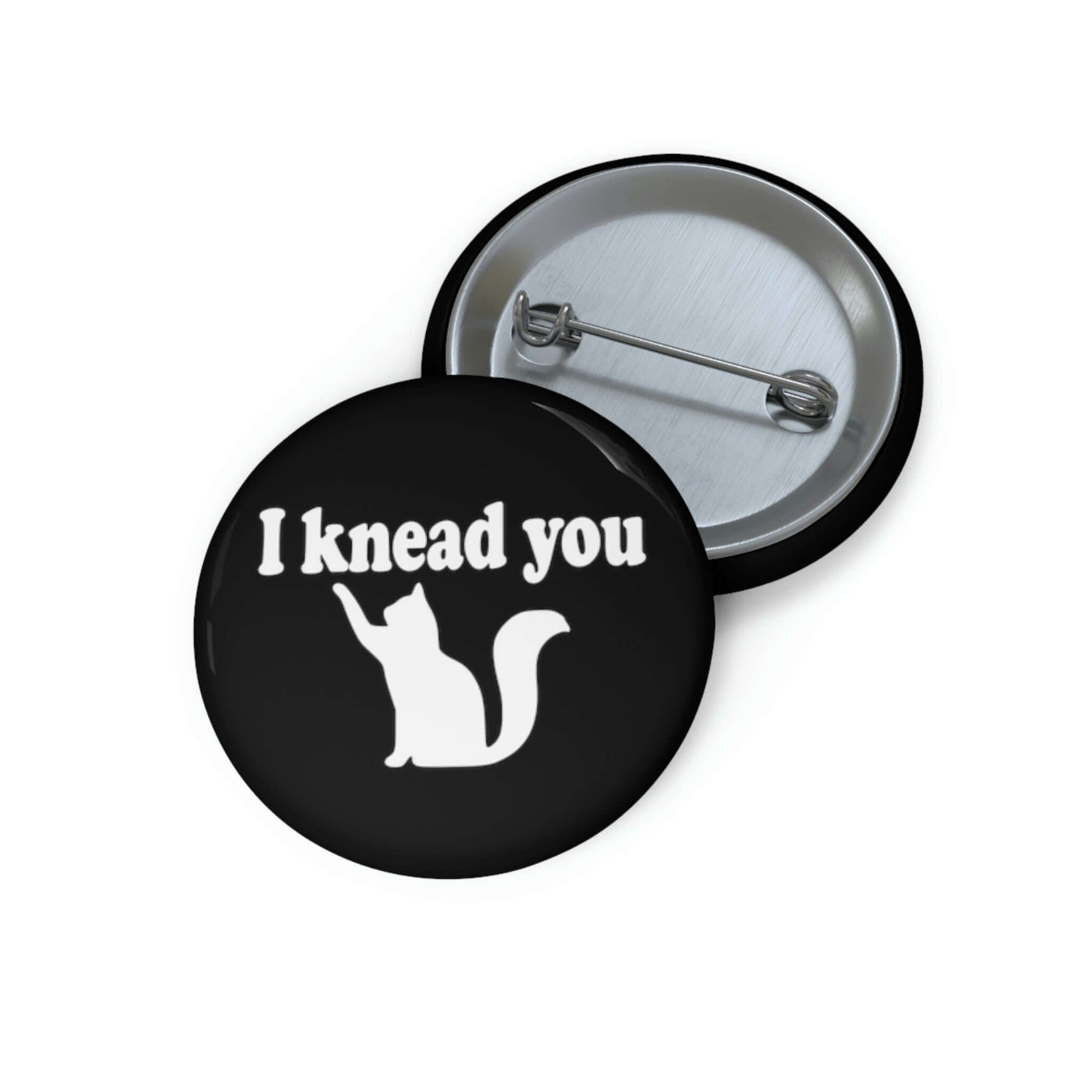 Pin-back button with silhouette of a cat and the words I knead you.