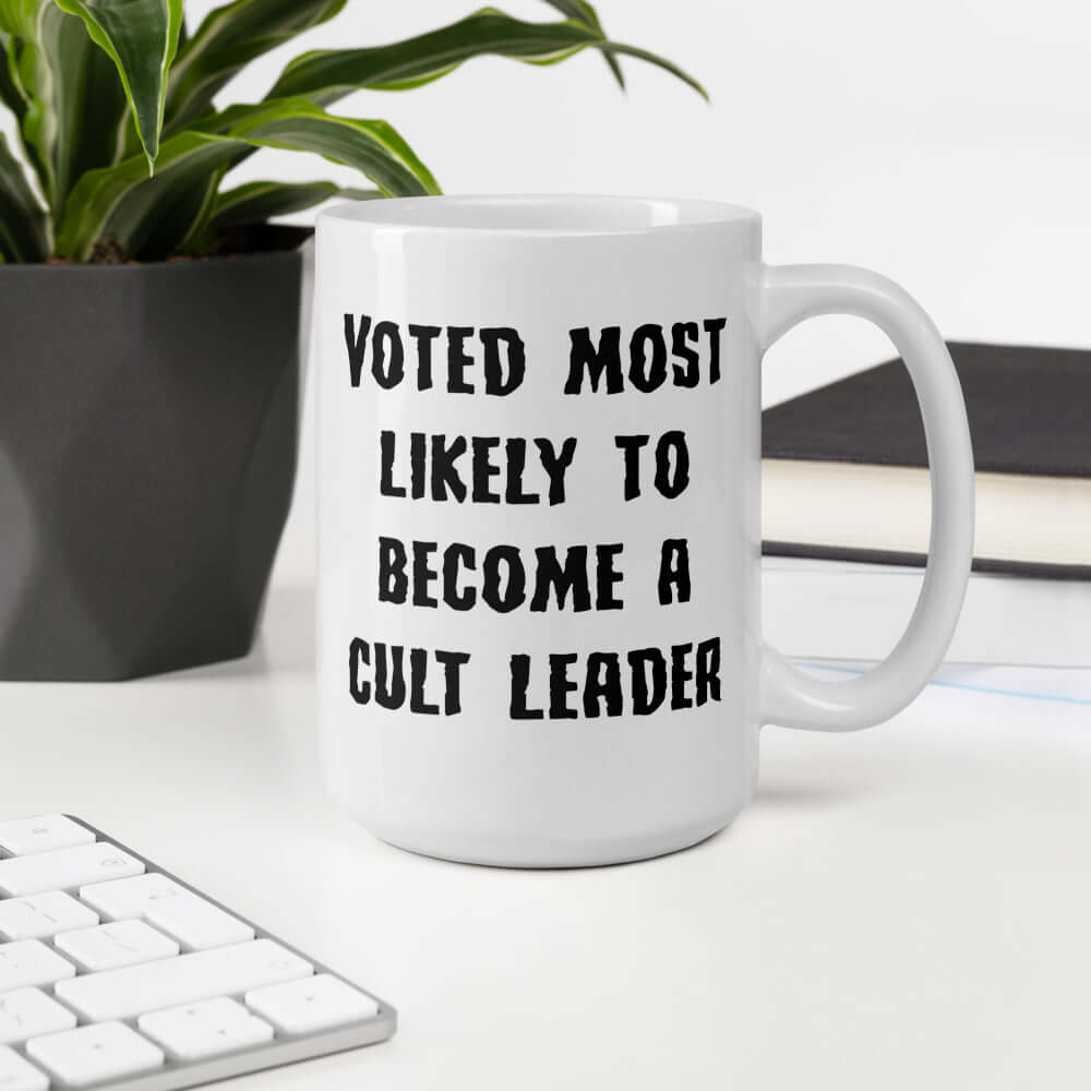 White ceramic mug with the words Voted most likely to become a cult leader printed on both sides. 