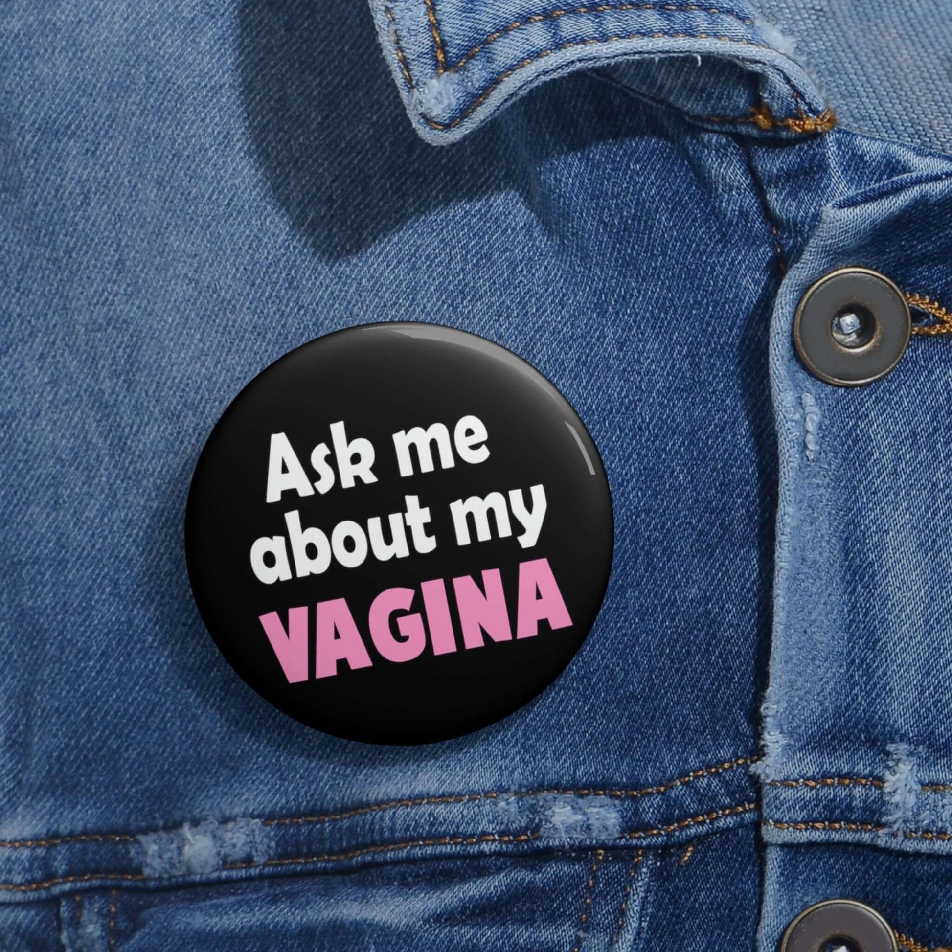 Black pinback button that says Ask me about my vagina. The word vagina is printed in pink. The rest of the text is white.