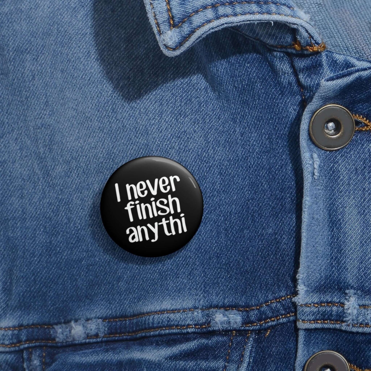 Pin-back button that says I never finish anything with the word anything missing the last 2 letters.