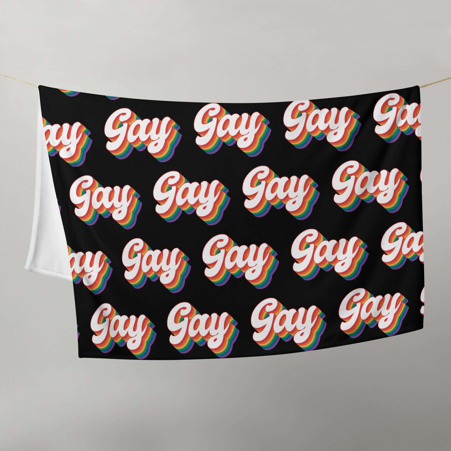 Black throw blanket with the word gay in rainbow font printed all over.