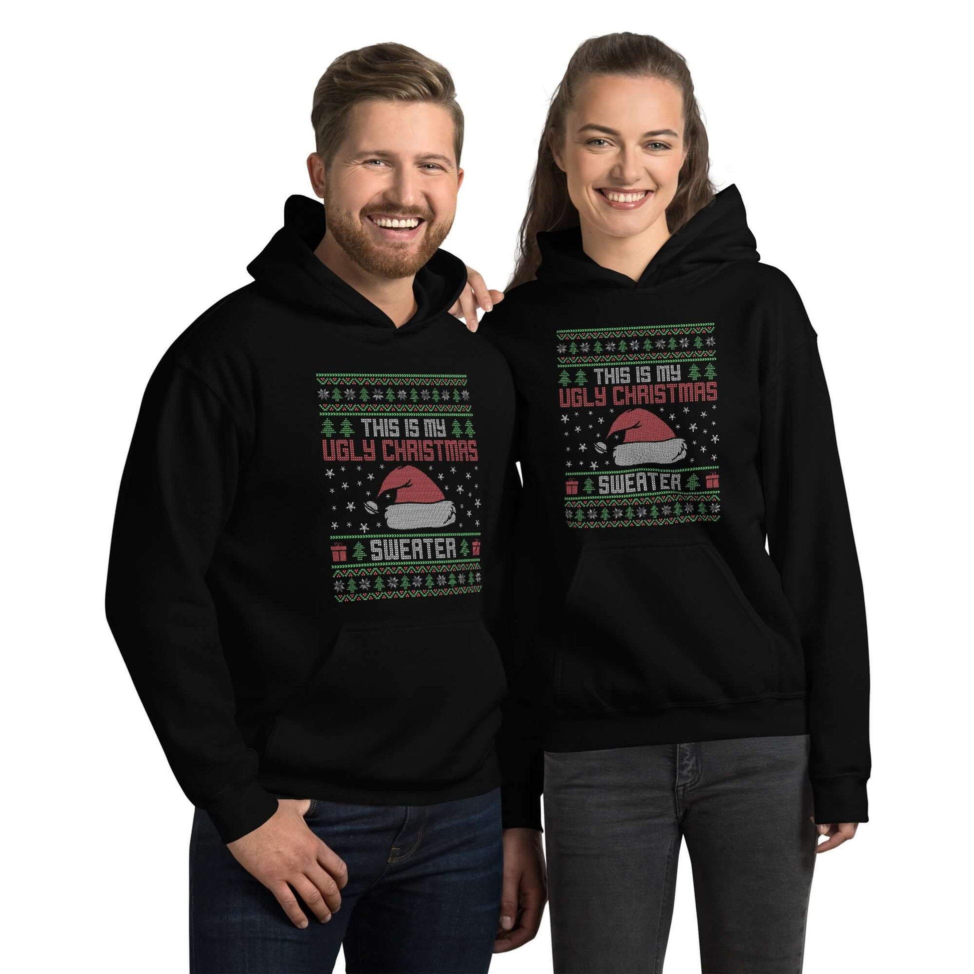 Man and a woman wearing black hooded sweatshirt with the words This is my ugly Christmas sweater printed on the front. 