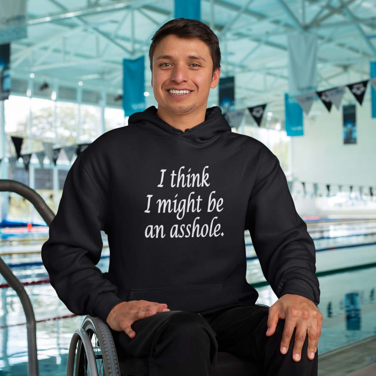 Man in a wheelchair wearing a black hoodie sweatshirt with the phrase I think I might be an asshole printed on the front.