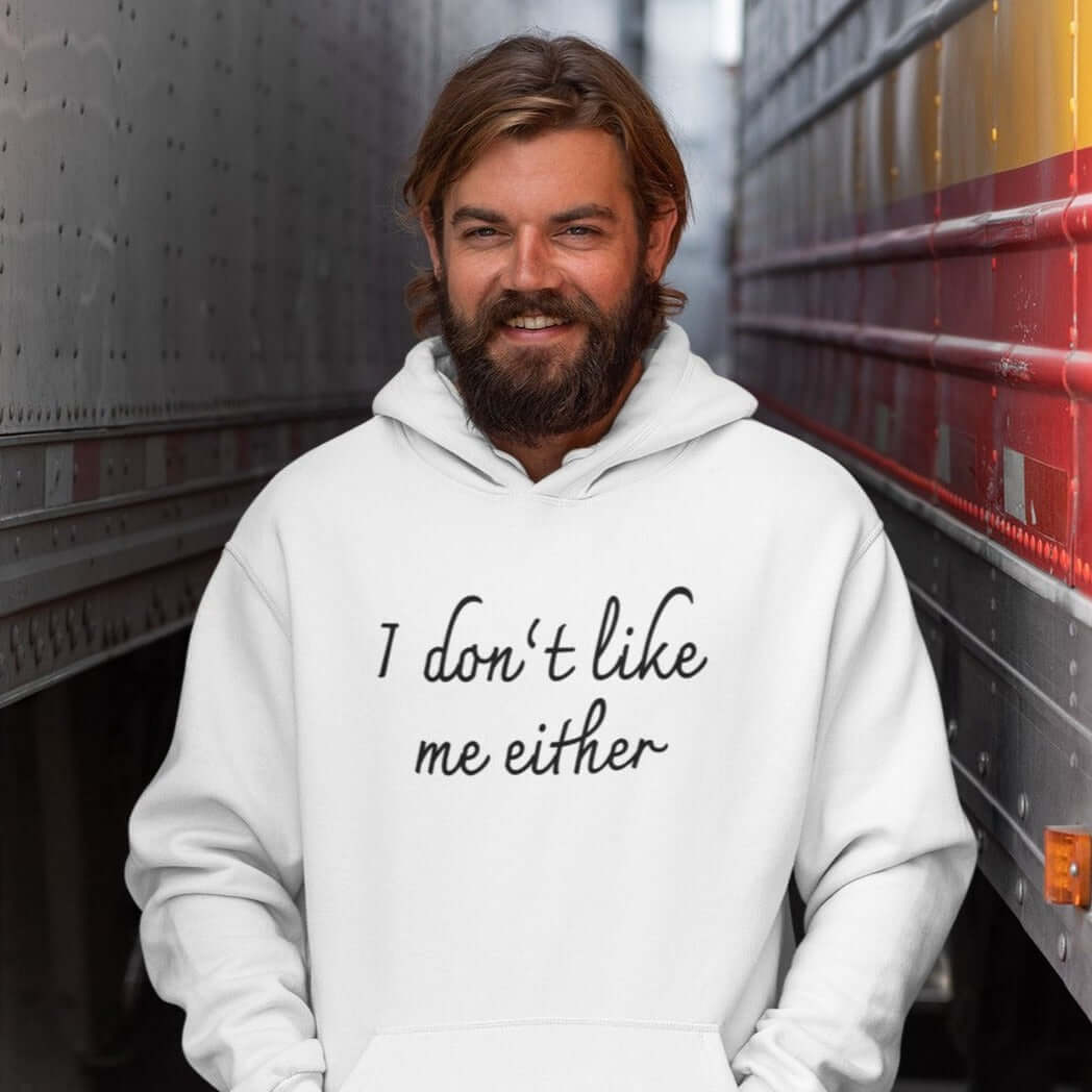 Man wearing white hooded sweatshirt with the words I don't like me either printed on the front.