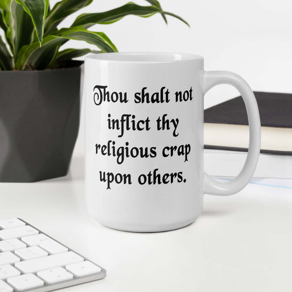 White ceramic coffee mug with the phrase Thou shalt not inflict thy religious crap upon others printed on both sides.