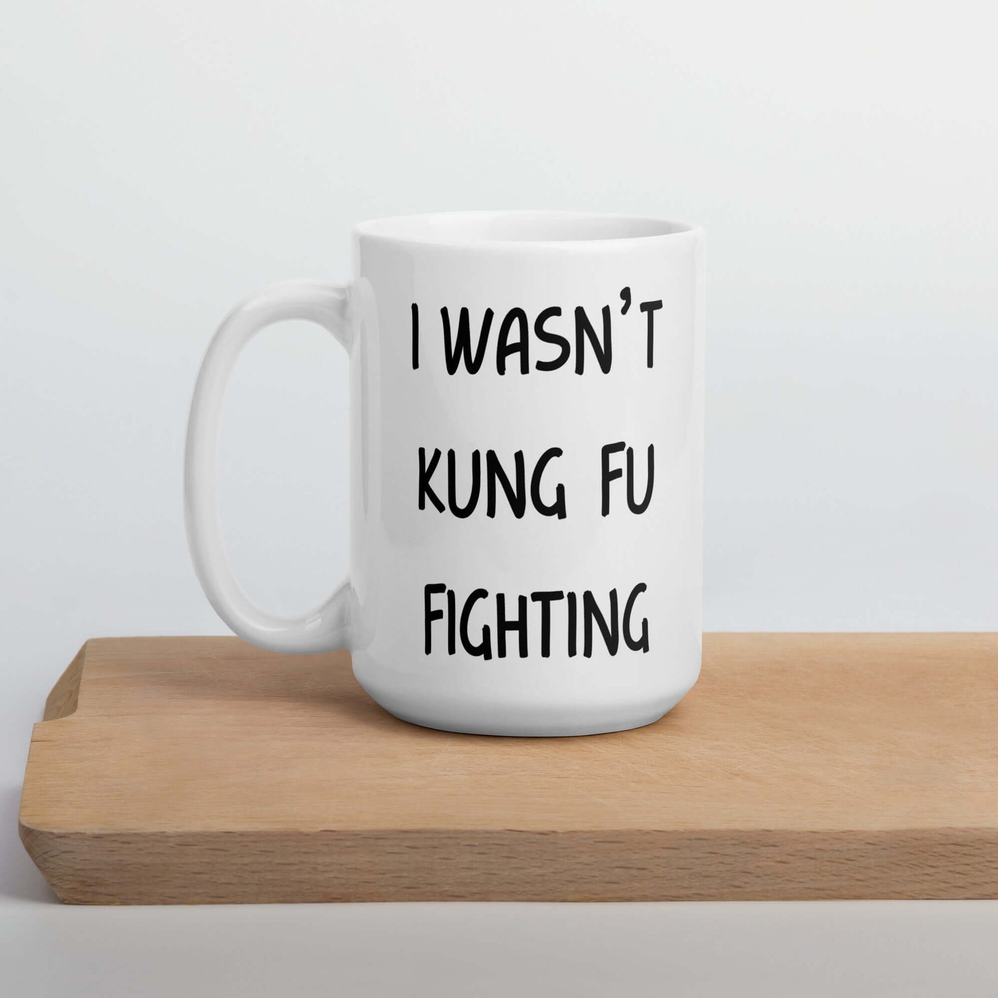 White ceramic coffee mug with the funny phrase I wasn't kung fu fighting printed on both sides.