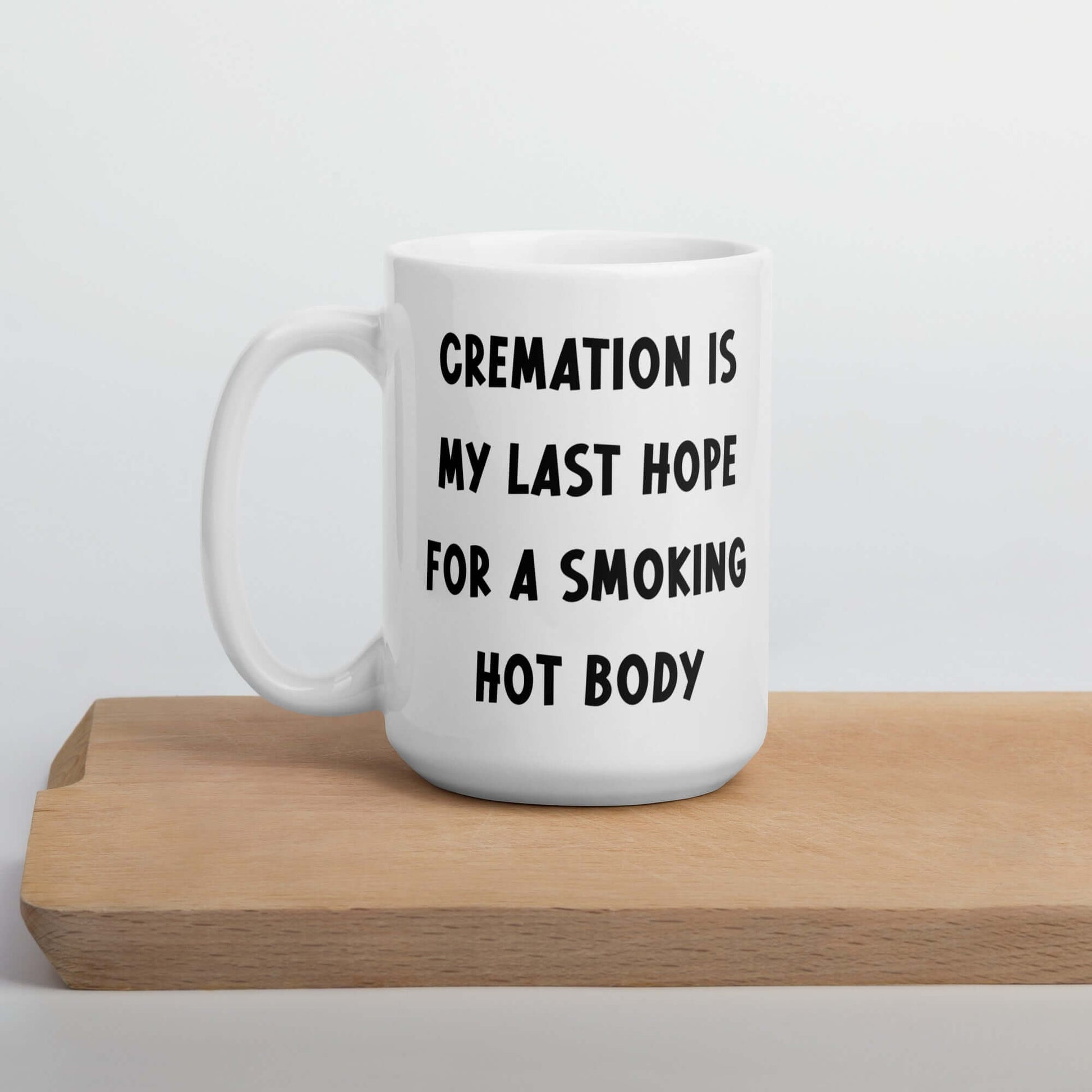 White ceramic mug with the words Cremation is my last hope for a smoking hot body printed on both sides.