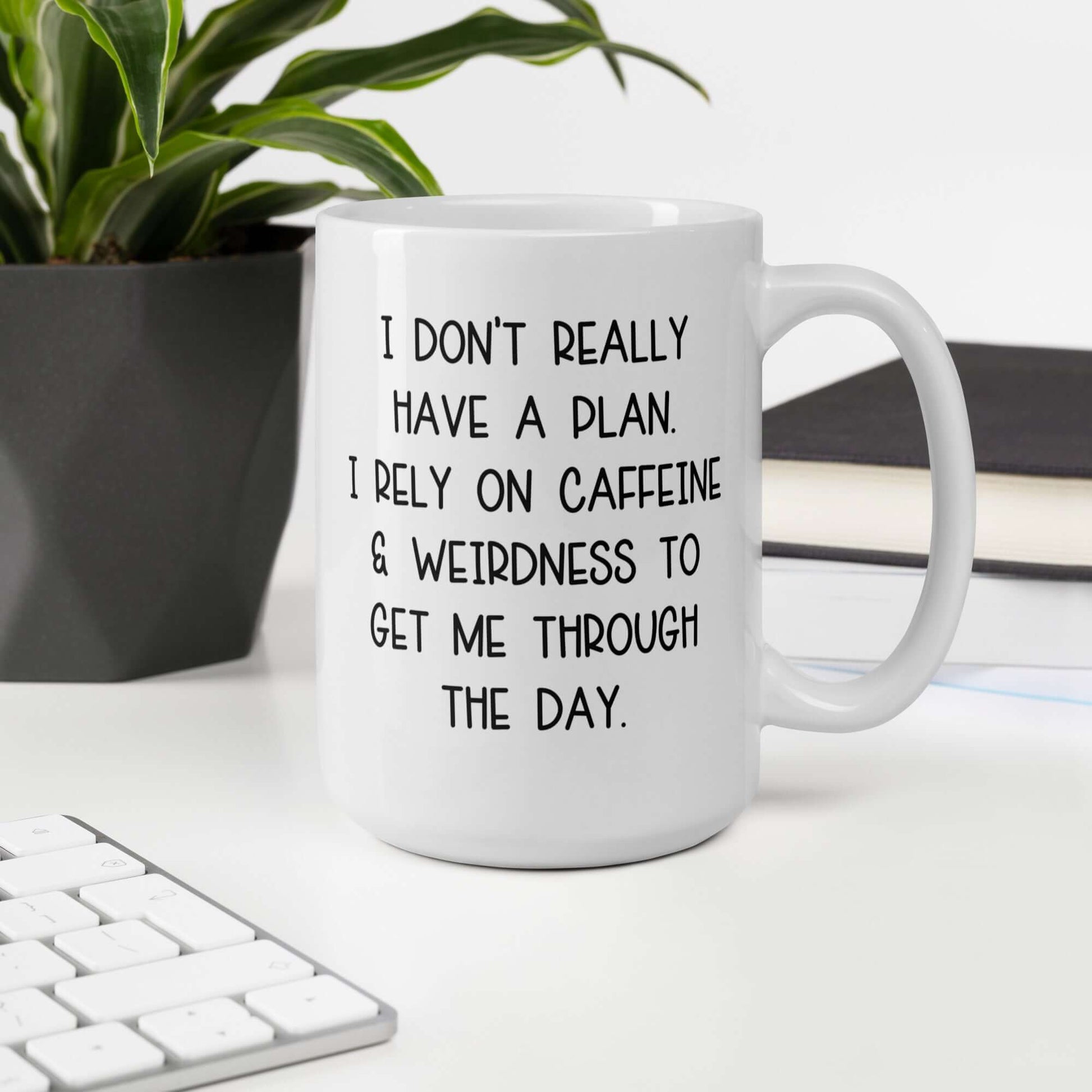 White ceramic mug with the words I don't really have a plan. I rely on caffeine & weirdness to get me through the day printed on both sides.