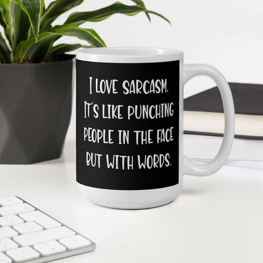 Black and white coffee mug with the phrase I love sarcasm, it's like punching people in the face but with words printed on both sides.