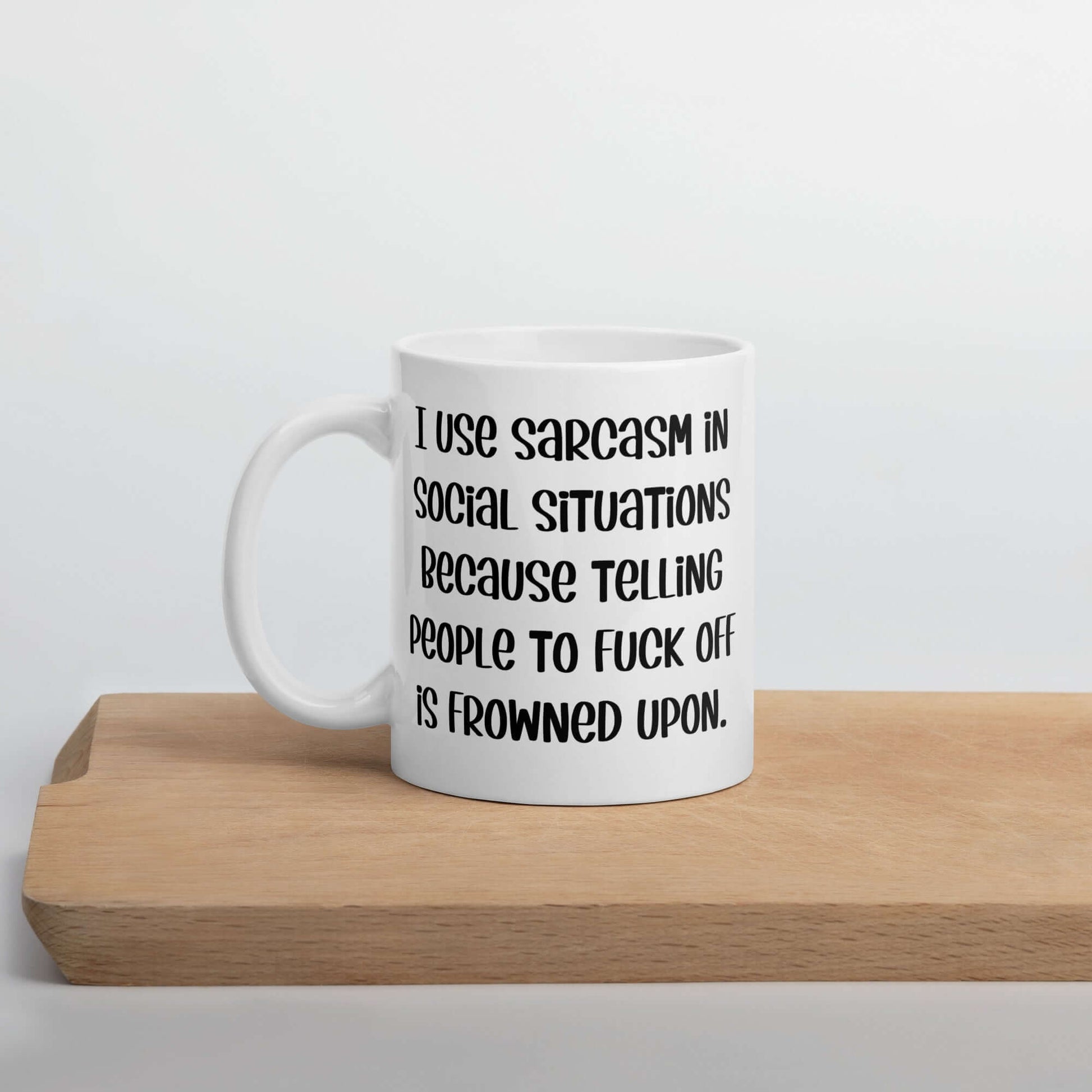 White ceramic mug with the phrase I use sarcasm in social situations because telling people to fuck off is frowned upon printed on both sides.