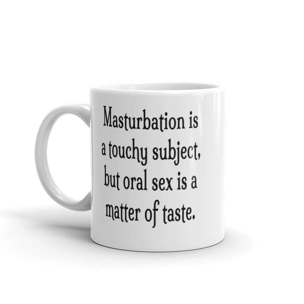 White ceramic coffee mug with the suggestive phrase Masturbation is a touchy subject, but oral sex is a matter of taste printed on both sides of the mug.