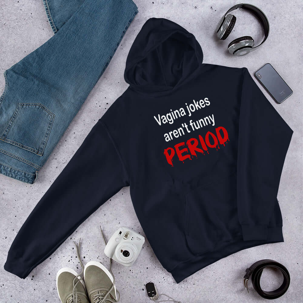 Navy blue hoodie sweatshirt with the crude phrase Vagina jokes aren't funny...period. The word period is in a red drippy font. The graphics are printed on the front of the hoodie.