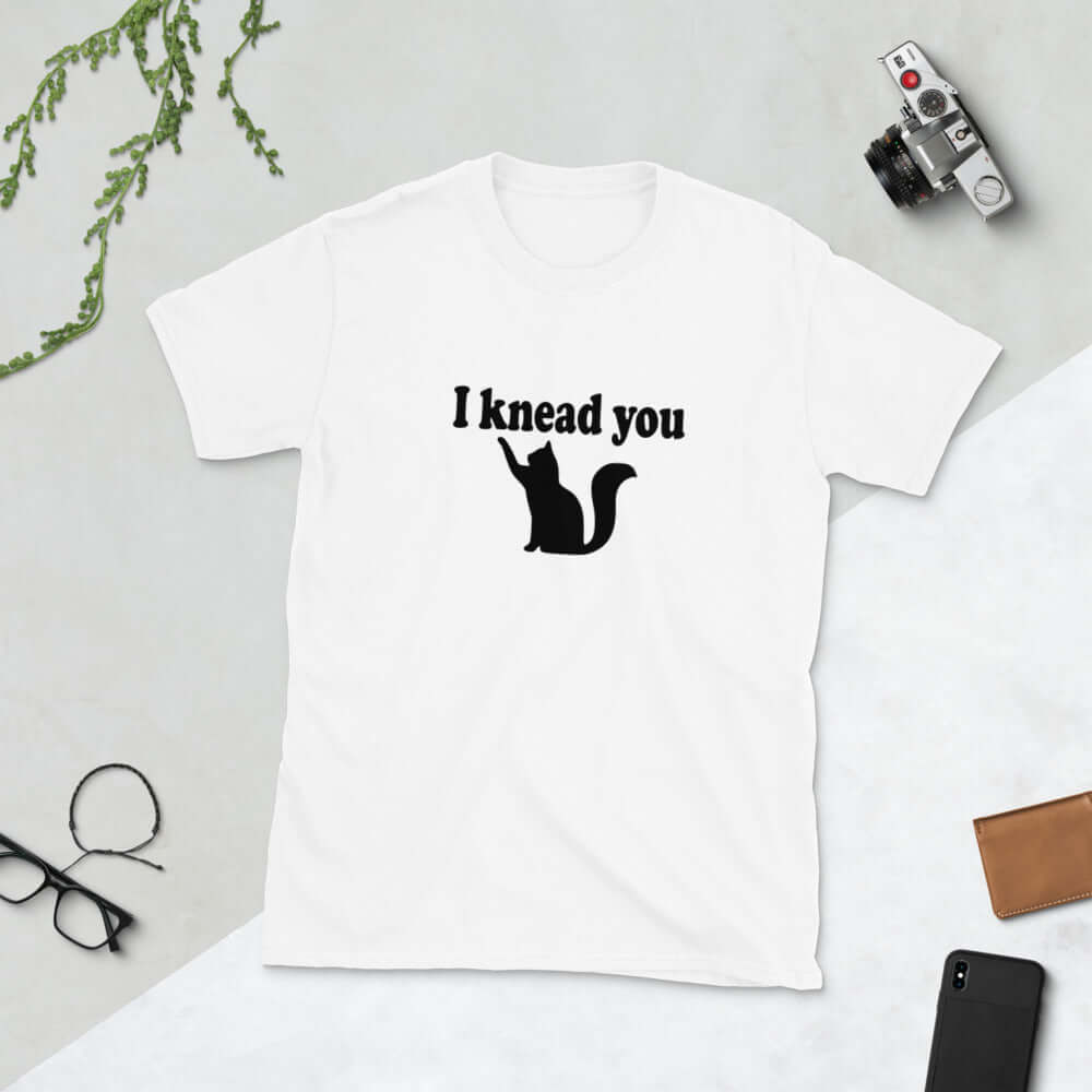 White t-shirt that has a pun image of a silhouette of a cat and the words I knead you printed on the front.