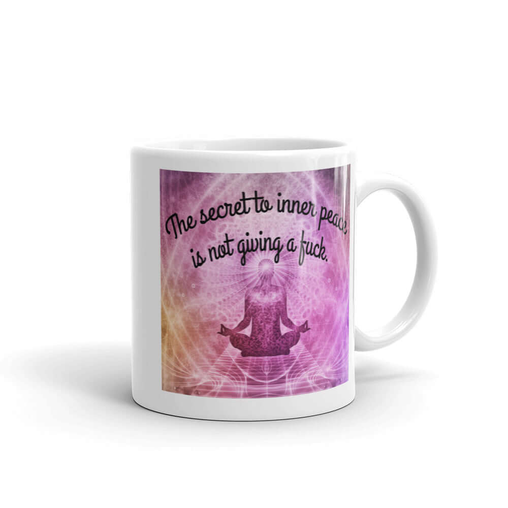 White ceramic coffee mug with a zen image and the phrase The secret to inner peace is not giving a fuck printed on both sides of the mug.