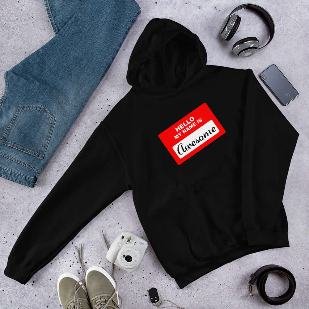 Black hoodie sweatshirt with an image of a classic red and white sticker name tag that says Hello my name is Awesome printed on the front.