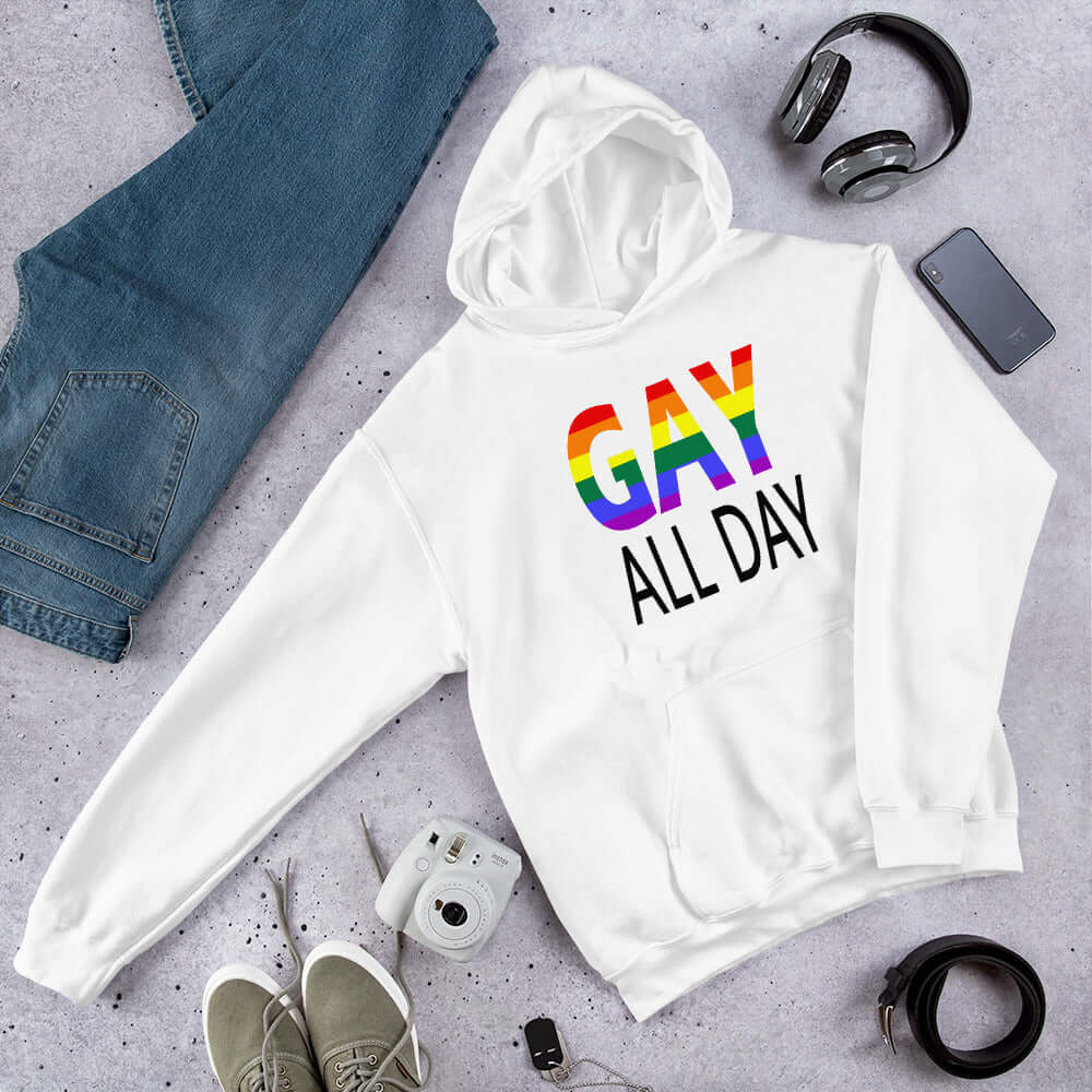 White hoodie sweatshirt with the words Gay all day printed on the front. The word Gay is in rainbow stripe font. 