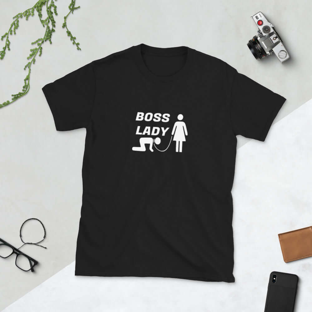 Black t-shirt with graphic of collared and leashed man on his hands and knees being led by a woman and the words Boss lady printed on the front.