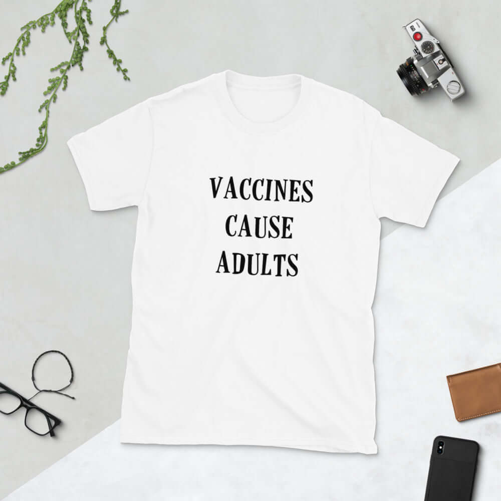 White t-shirt with the words Vaccines cause adults printed on the front.