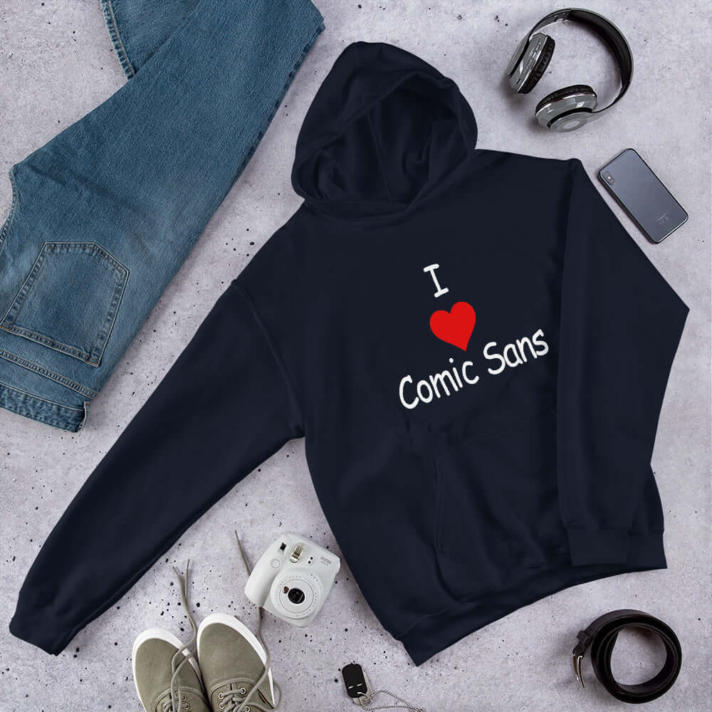 Navy blue hoodie sweatshirt with the phrase I heart Comic Sans on the front. The text is in comic sans font.