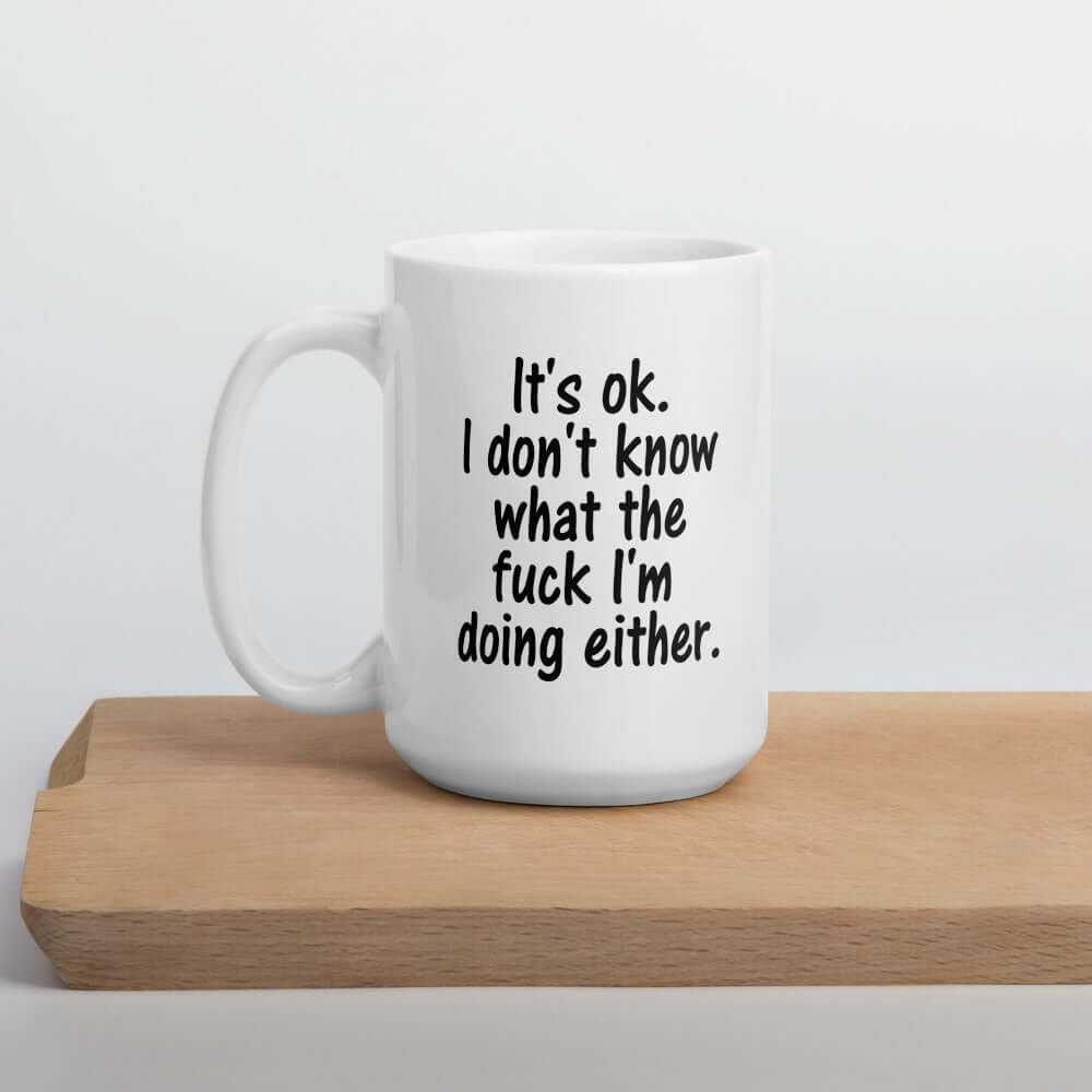 White ceramic coffee mug with the phrase It's ok, I don't know what the fuck I'm doing either printed on both sides of the mug.