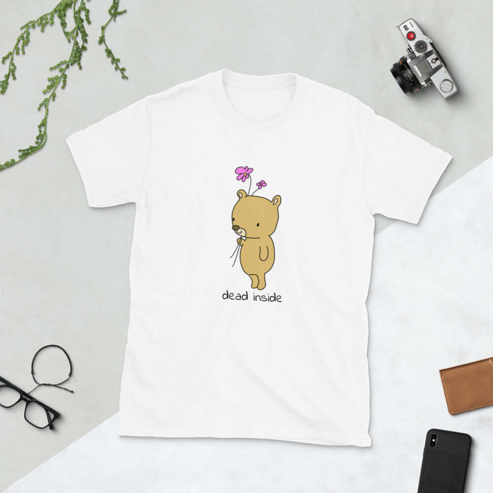 White t-shirt with an image of a cute bear holding 2 pink flowers. The words Dead inside are printed underneath the bear. The graphics are printed on the front of the shirt.