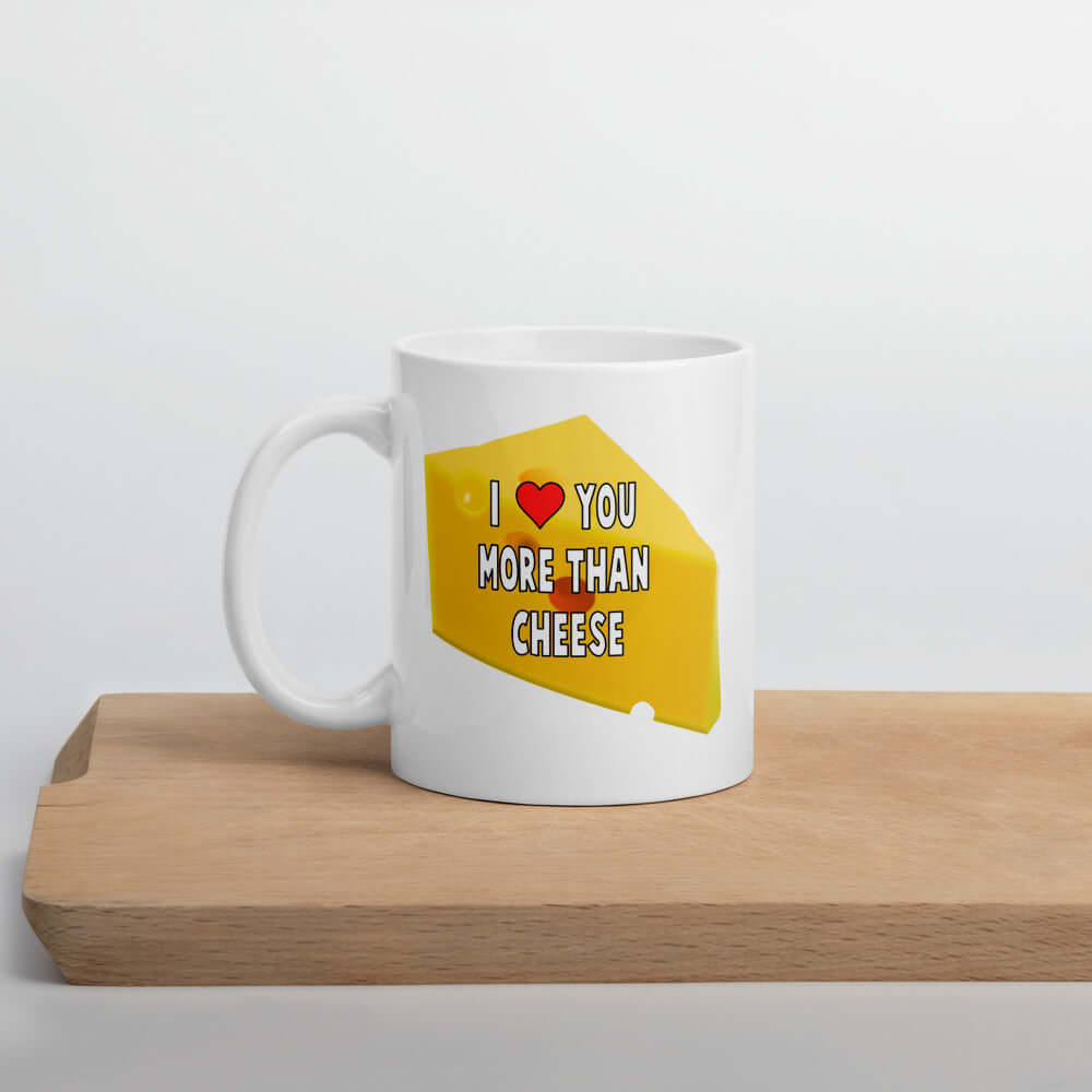 White ceramic coffee mug with an image of a wedge of cheese and the phrase I heart you more than cheese printed on both sides.