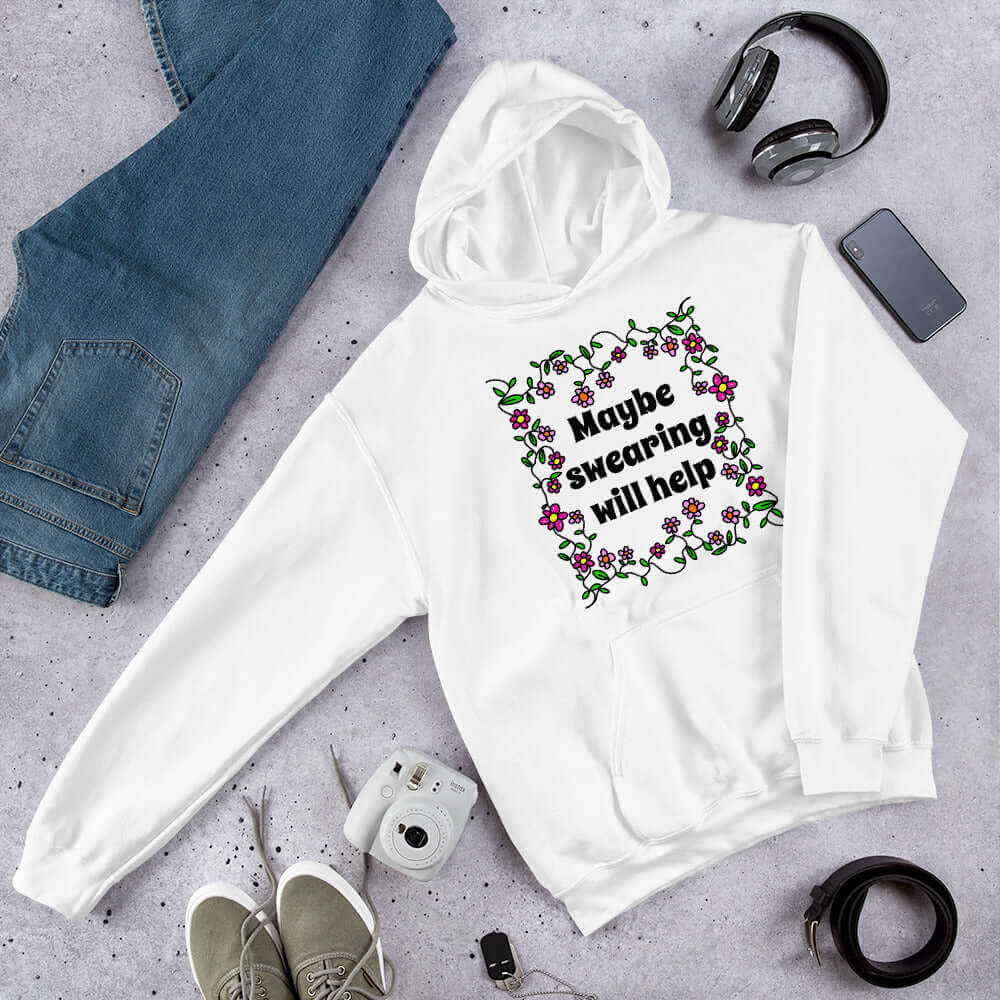 White hoodie sweatshirt with a floral graphic and the phrase Maybe swearing will help printed on the front.