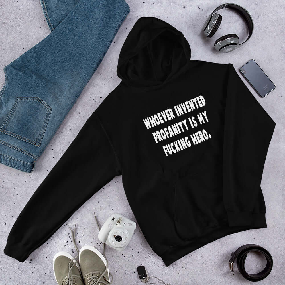 Black hoodie sweatshirt with the phrase Whoever invented profanity is my fucking hero printed on the front.