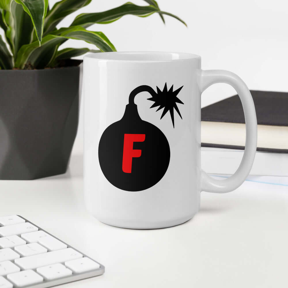 White ceramic coffee mug with an image of a bomb & the letter F printed in the center. The graphics are printed on both sides of the mug.