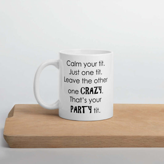 White ceramic coffee mug with the funny phrase Calm your tit, just one tit. Leave the other one crazy, that's your party tit printed on both sides.