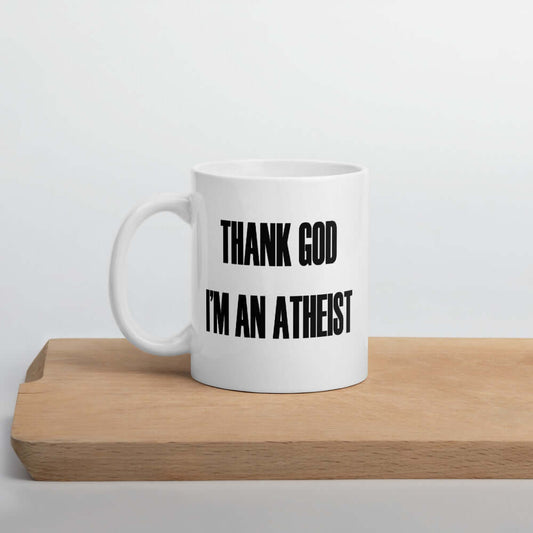 White ceramic mug with the words Thank God I'm an atheist printed on both sides.