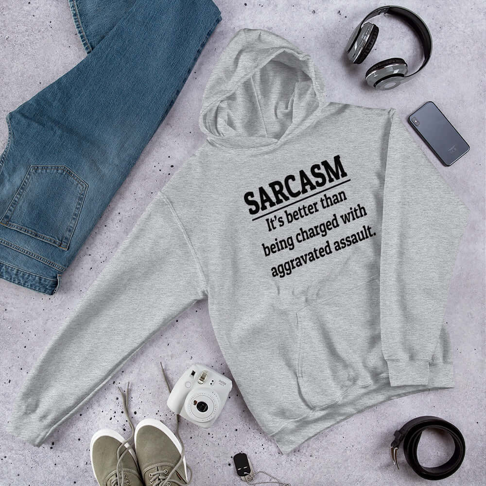 Light grey hoodie sweatshirt with the phrase Sarcasm, it's better than being charged with aggravated assault printed on the front of the hoodie.
