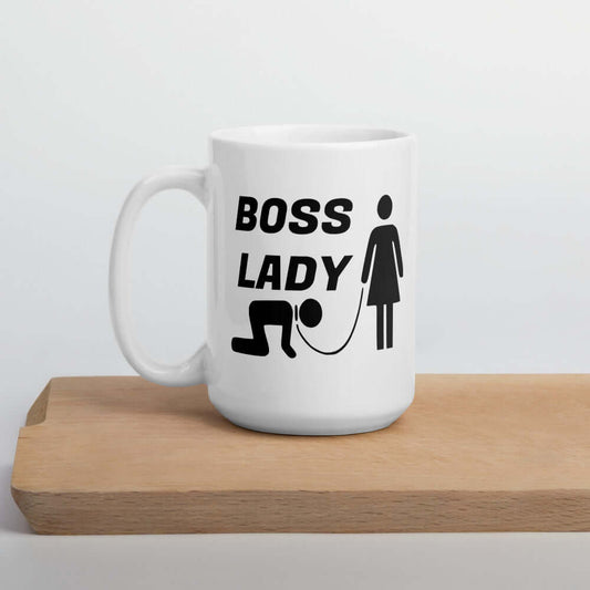 White ceramic mug with graphic of collared and leashed man on his hands and knees being led by a woman and the words Boss lady printed on both sides.