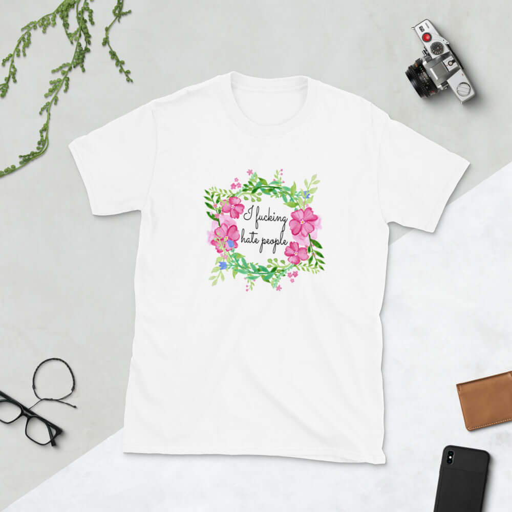 White t-shirt with pink and green floral wreath image and the words I fucking hate people printed on the front.