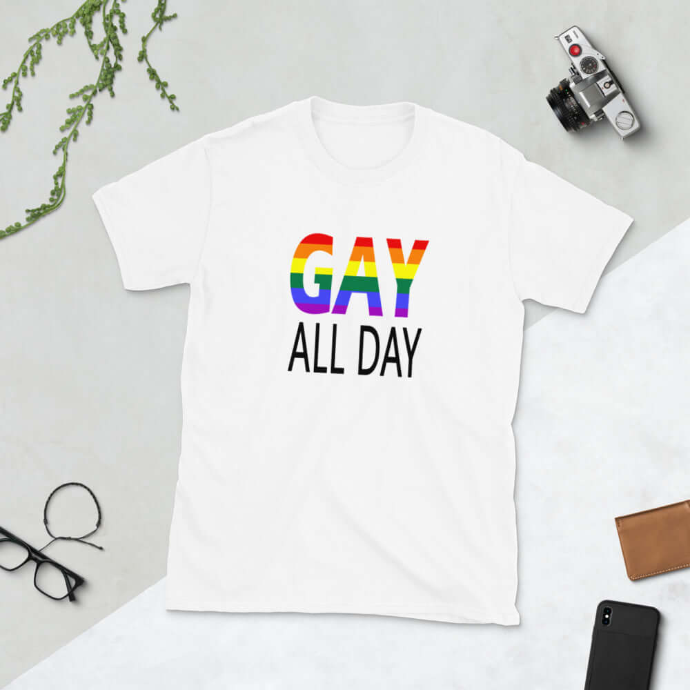 White t-shirt with the words Gay all day printed on the front. The word Gay is in rainbow stripe font. 