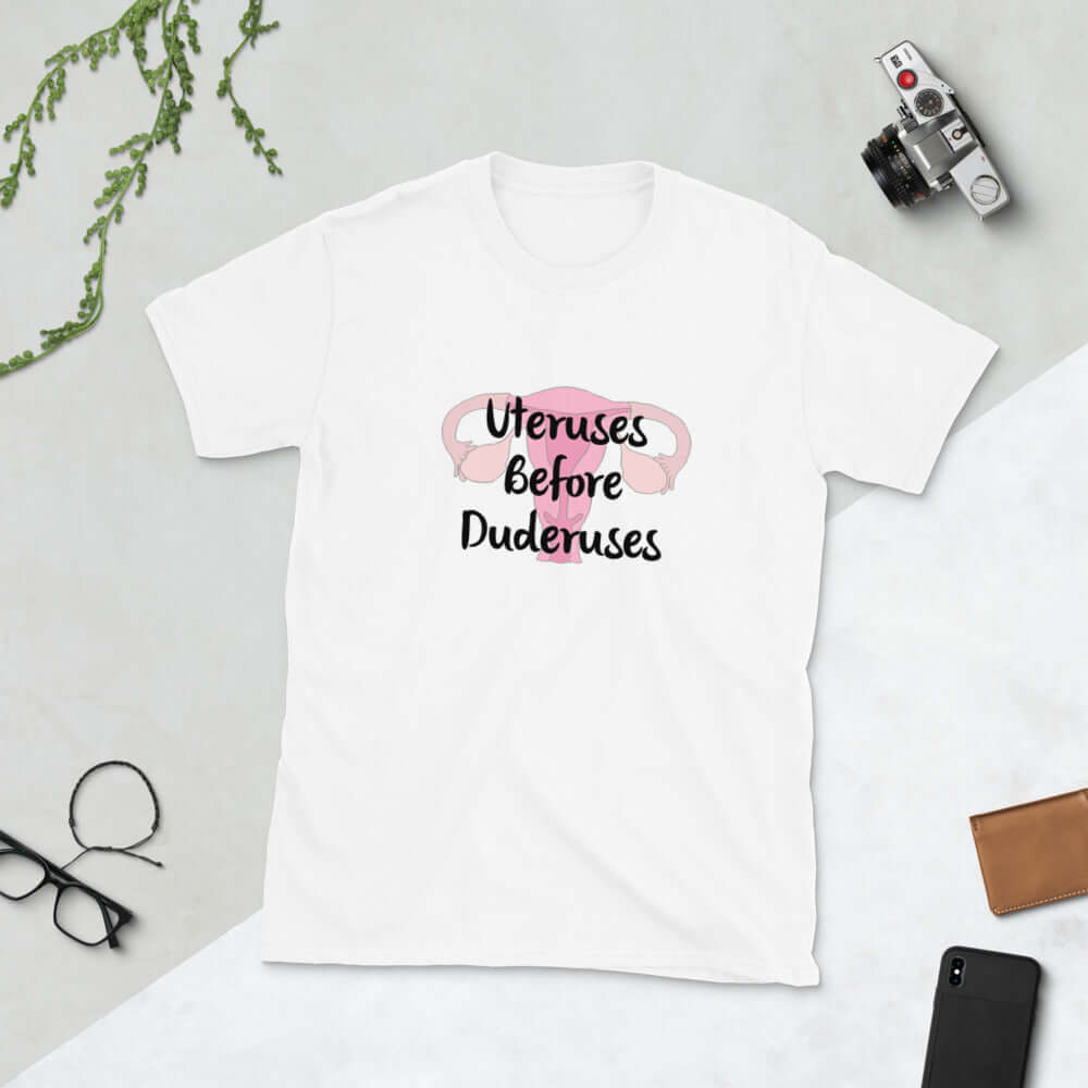 White t-shirt with image of a uterus and the words Uteruses before duderuses printed on the front.