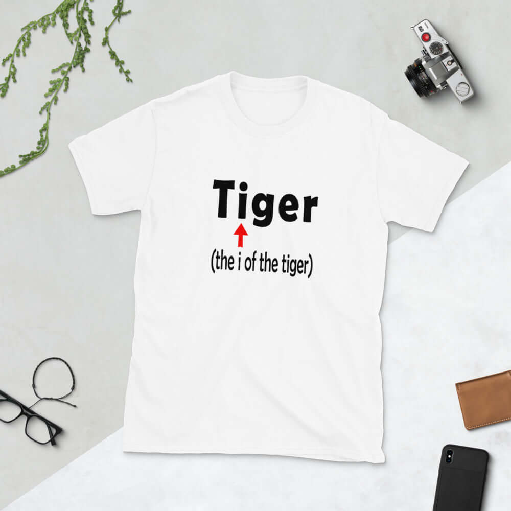 White t-shirt with the word Tiger and in smaller letters it says the I of the tiger with an arrow pointing to the letting I in the words tiger. The graphics are printed on the front of the shirt.