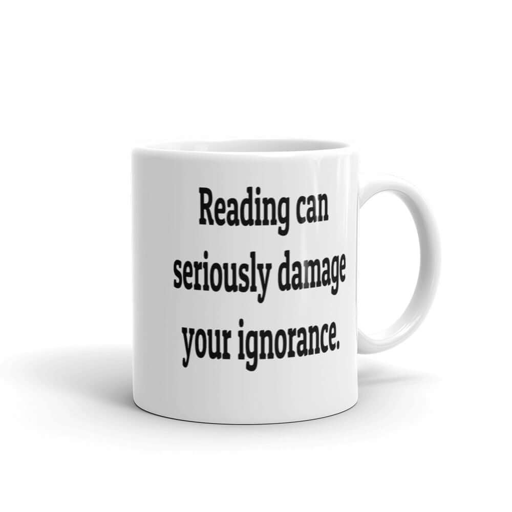 White ceramic mug with the phrase Reading can seriously damage your ignorance printed on both sides of the mug.
