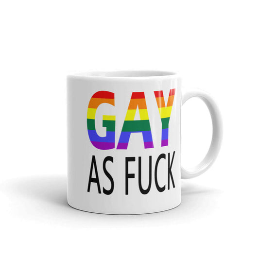 White ceramic mug with the words Gay as fuck printed on both sides. The word Gay is in rainbow stripe font.