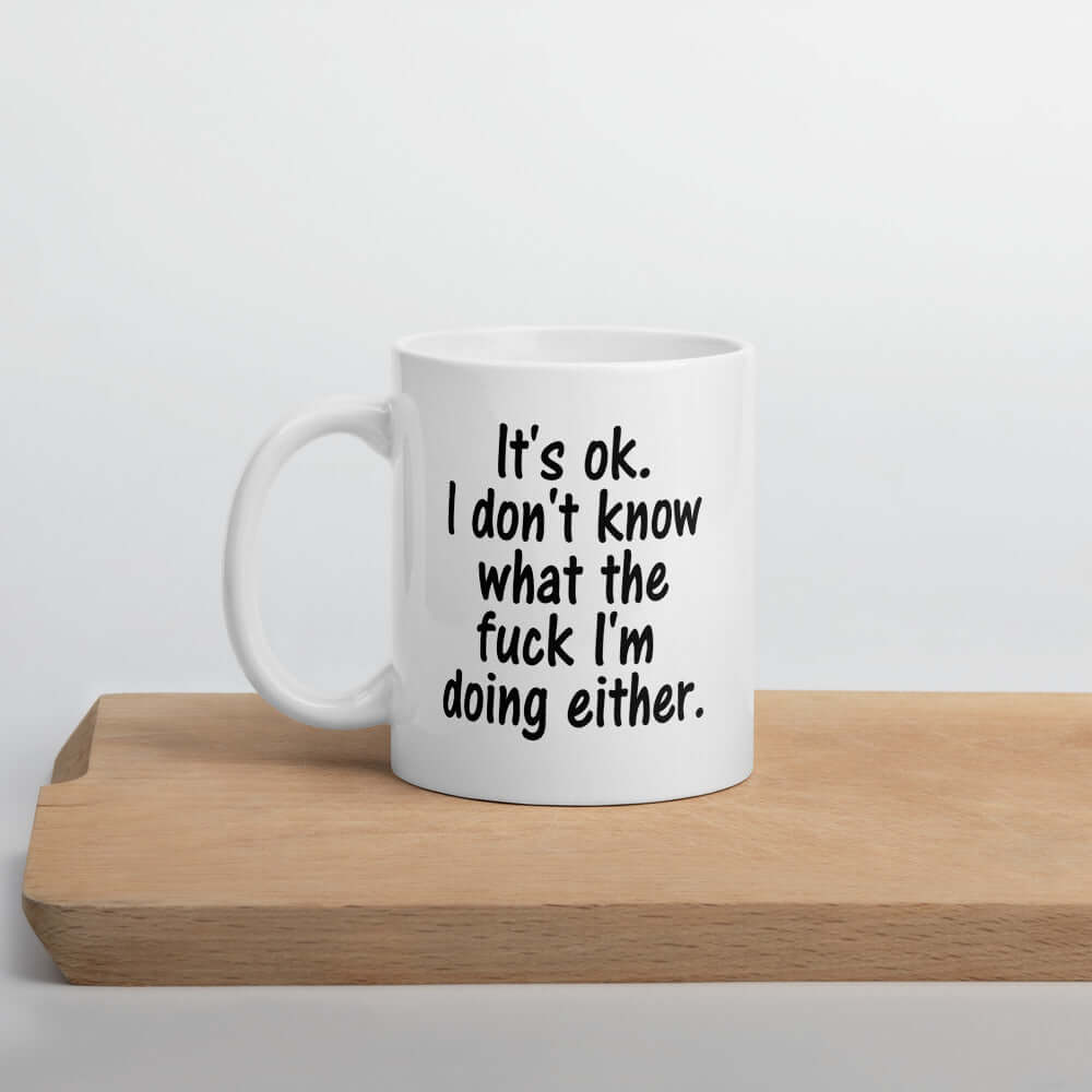 White ceramic coffee mug with the phrase It's ok, I don't know what the fuck I'm doing either printed on both sides of the mug.