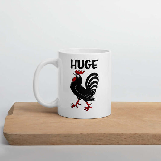 White ceramic mug with an image of a rooster and the word Huge above the rooster printed on both sides.