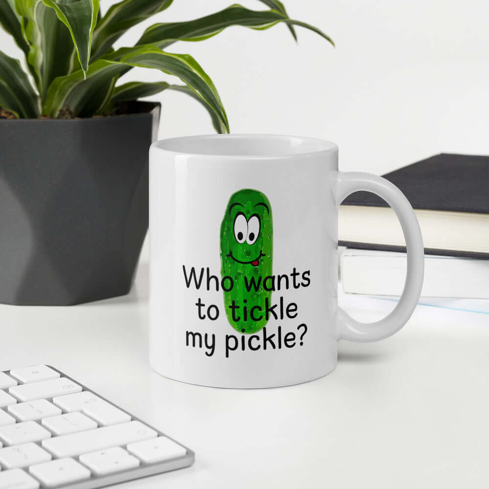 White ceramic coffee mug with an image of a pickle printed on both sides. The words Who wants to tickle my pickle are printed under the pickle.