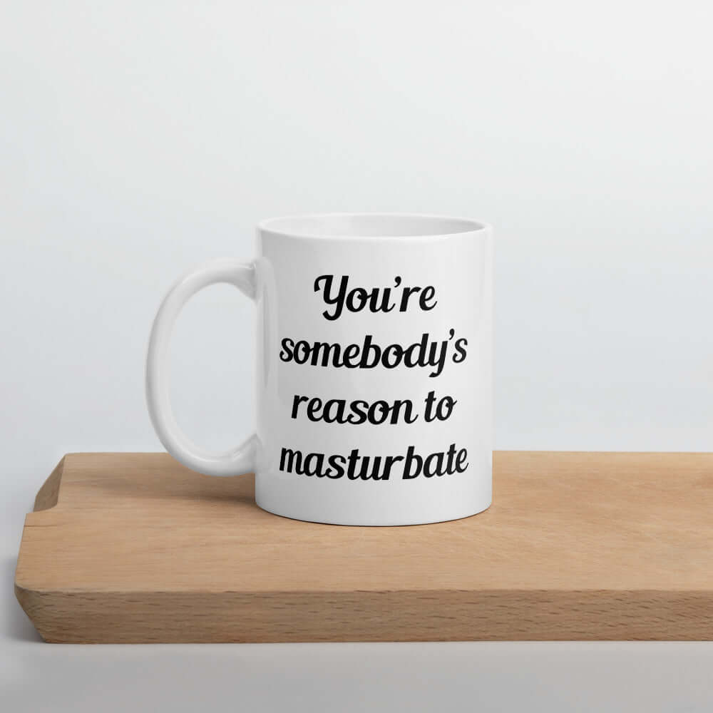 White ceramic coffee mug with the phrase You're somebody's reason to masturbate printed on both sides of the mug.